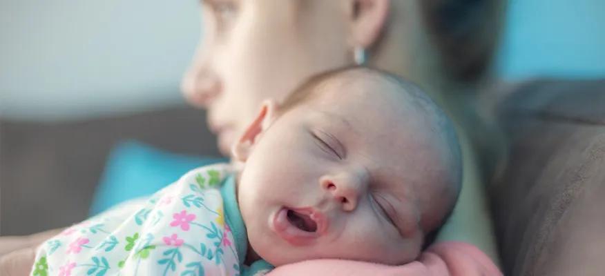 New mother holding her baby, symbolizing postpartum changes and recovery