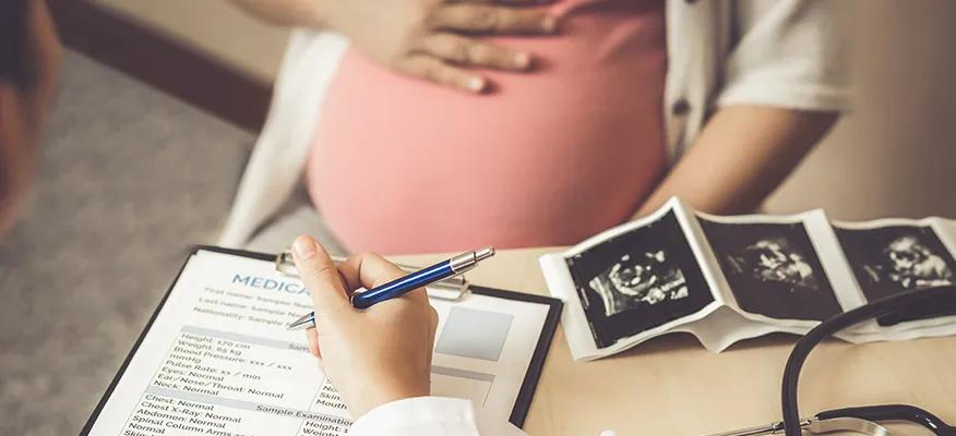 Pregnant woman in third trimester holding her belly, highlighting the signs and symptoms to watch for during this stage.